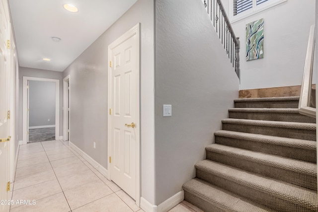 staircase with tile patterned flooring, baseboards, and recessed lighting