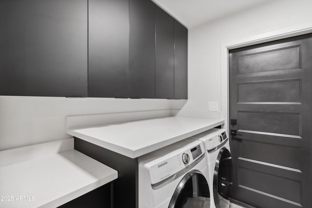 clothes washing area featuring cabinets and washer and clothes dryer