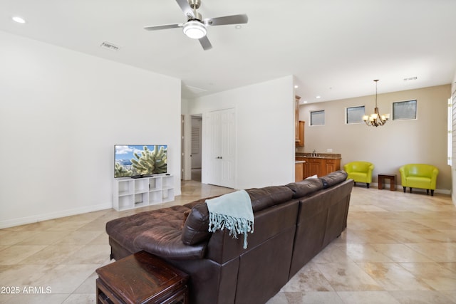 living room with ceiling fan with notable chandelier