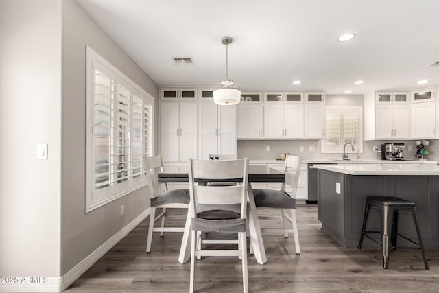 4142 E Sandy Way, Gilbert, AZ 85297 - kitchen featuring a breakfast bar, white cabinets, wood finished floors, light countertops, and a sink