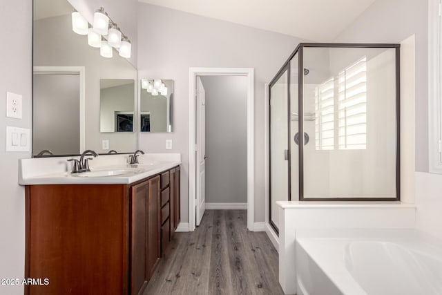 4142 E Sandy Way, Gilbert, AZ 85297 - bathroom featuring a shower stall, a garden tub, wood finished floors, double vanity, and baseboards