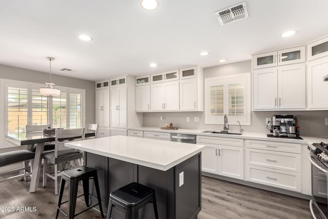 4142 E Sandy Way, Gilbert, AZ 85297 - kitchen with a sink, a kitchen bar, white cabinets, light countertops, and a kitchen island