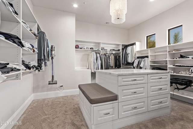 walk in closet with a notable chandelier and carpet flooring