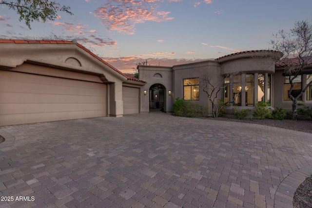 mediterranean / spanish home featuring a garage