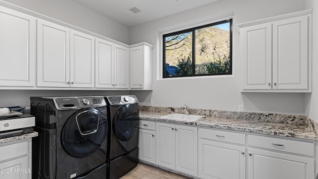 laundry room featuring separate washer and dryer, sink, and cabinets