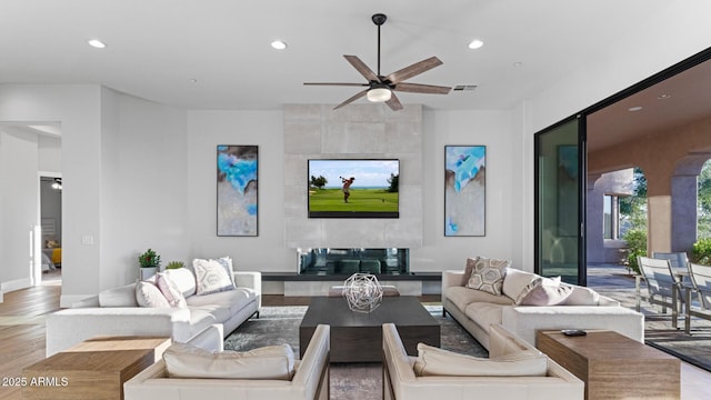 living room with light hardwood / wood-style flooring and ceiling fan