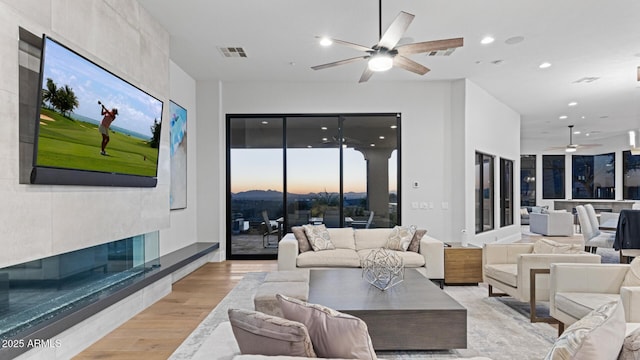 living room with ceiling fan and light hardwood / wood-style floors