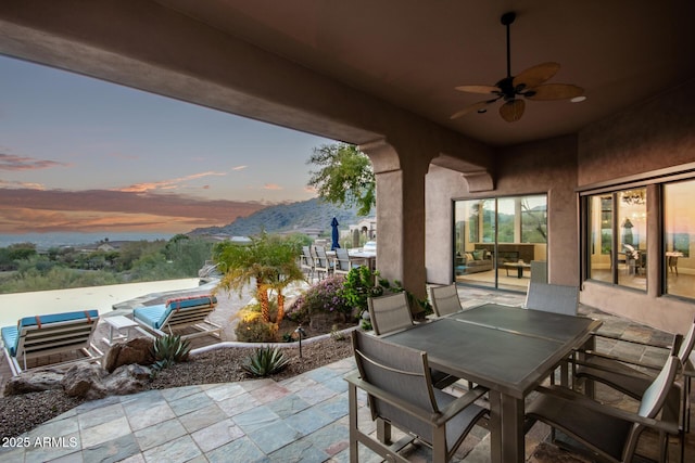 patio terrace at dusk featuring ceiling fan