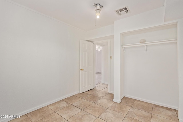2562 E Wier Ave, Phoenix, AZ 85040 - unfurnished bedroom with light tile patterned flooring, a closet, and baseboards