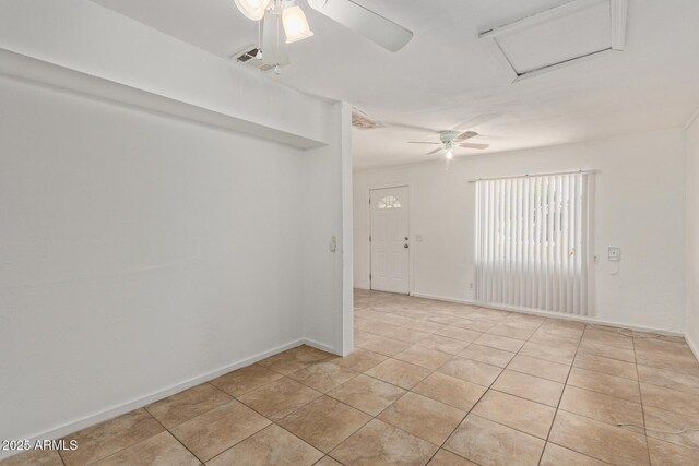 2562 E Wier Ave, Phoenix, AZ 85040 - spare room with ceiling fan, attic access, light tile patterned flooring, and baseboards