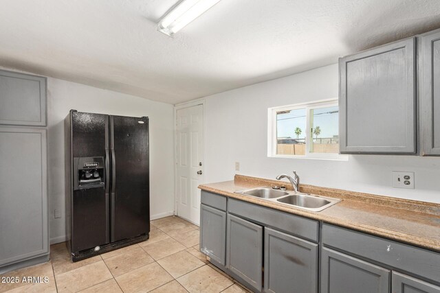 2562 E Wier Ave, Phoenix, AZ 85040 - kitchen featuring black refrigerator with ice dispenser, gray cabinets, a sink, and light tile patterned floors