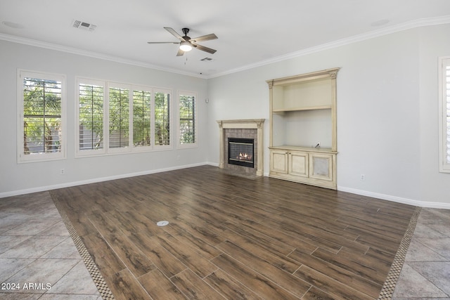 unfurnished living room featuring hardwood / wood-style flooring, ornamental molding, ceiling fan, and a fireplace