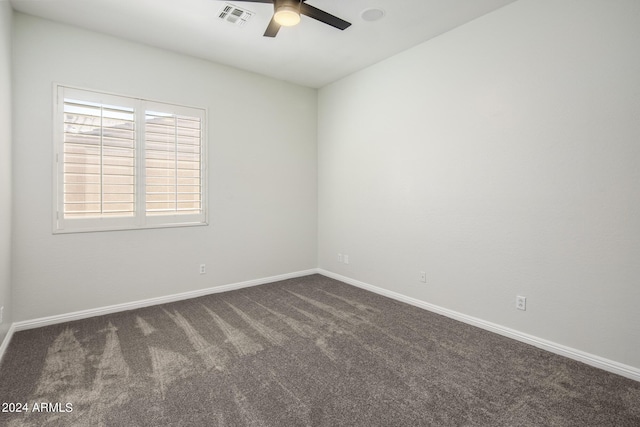 spare room with ceiling fan and dark colored carpet