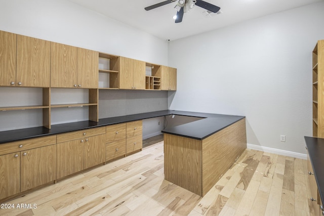 kitchen with ceiling fan, built in desk, and light hardwood / wood-style flooring