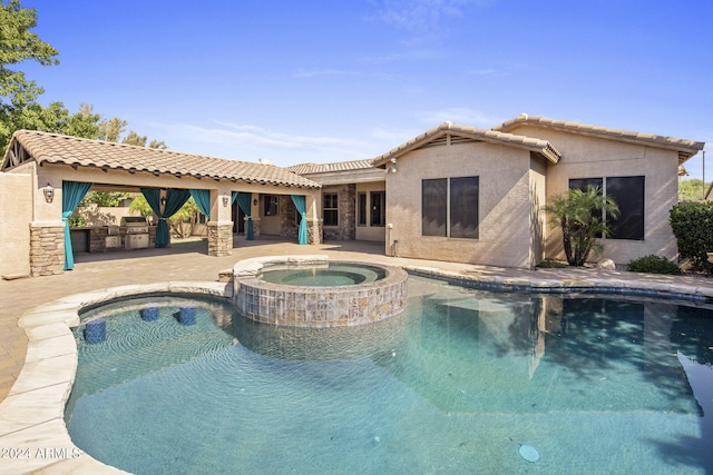 view of swimming pool with an in ground hot tub, area for grilling, and a patio area