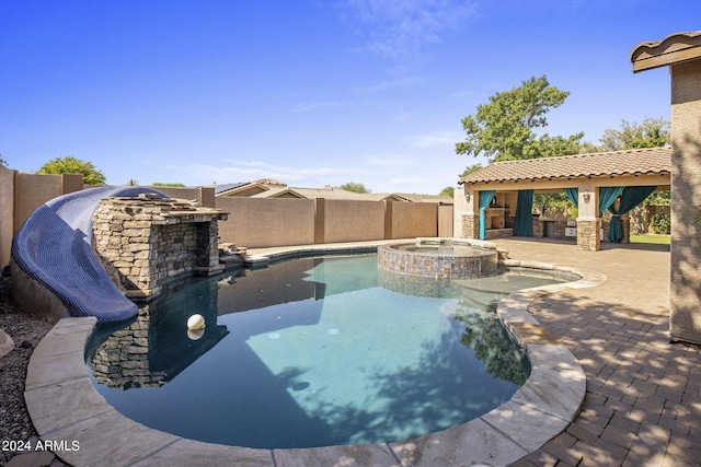 view of swimming pool featuring an in ground hot tub, area for grilling, and a patio area