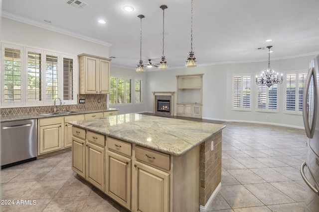 kitchen featuring appliances with stainless steel finishes, pendant lighting, sink, backsplash, and a center island