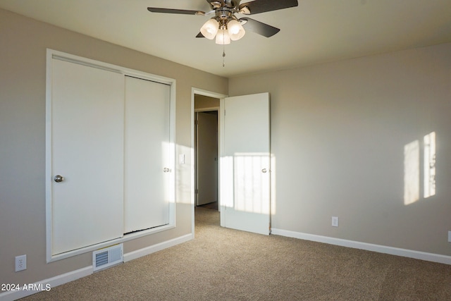 unfurnished bedroom featuring a closet, ceiling fan, and light colored carpet