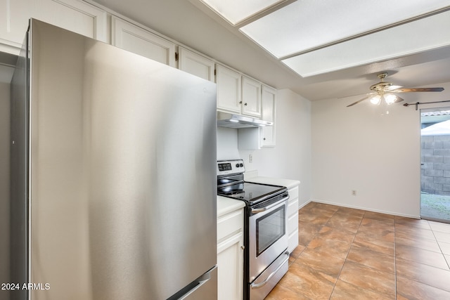 kitchen with appliances with stainless steel finishes, light tile patterned floors, white cabinetry, and ceiling fan