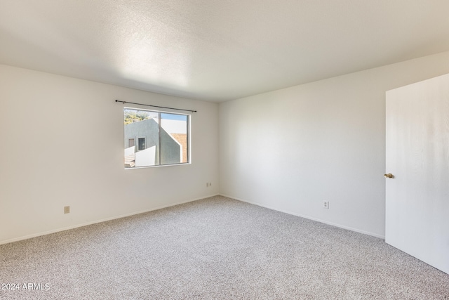 empty room with a textured ceiling and carpet floors