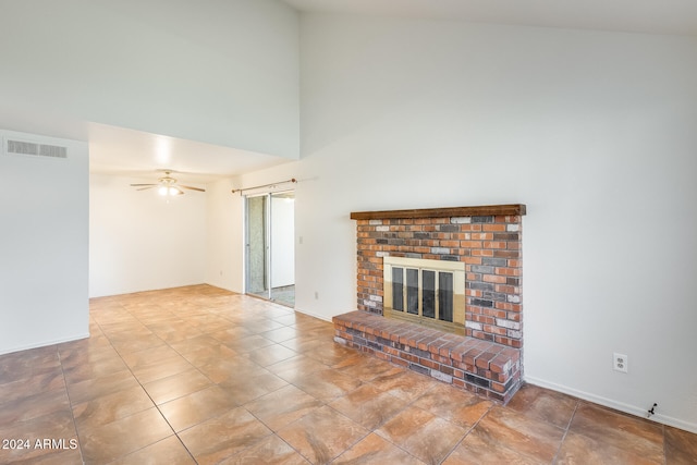 unfurnished living room with ceiling fan, a fireplace, and high vaulted ceiling