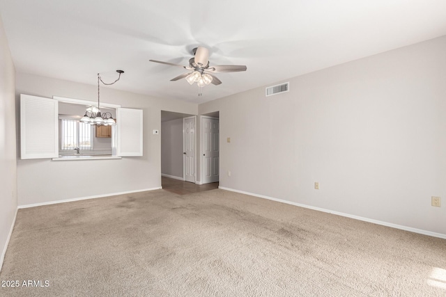 unfurnished room featuring carpet and ceiling fan with notable chandelier