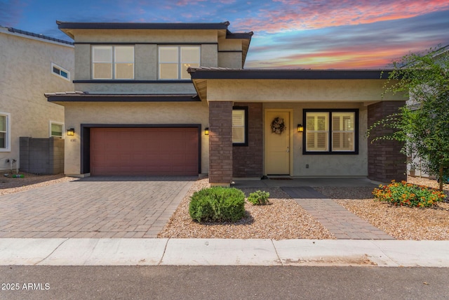 1857 W 22nd Ave, Apache Junction, AZ 85120 - view of front of house with an attached garage, a porch, stucco siding, decorative driveway, and stone siding