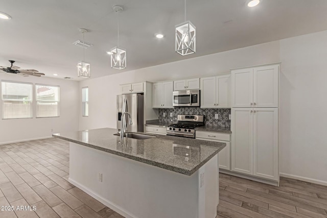 1857 W 22nd Ave, Apache Junction, AZ 85120 - kitchen with stainless steel appliances, a sink, light wood-type flooring, decorative backsplash, and baseboards