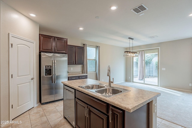 kitchen with visible vents, a sink, stainless steel appliances, dark brown cabinetry, and light carpet