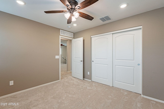 unfurnished bedroom with recessed lighting, light colored carpet, visible vents, and a closet