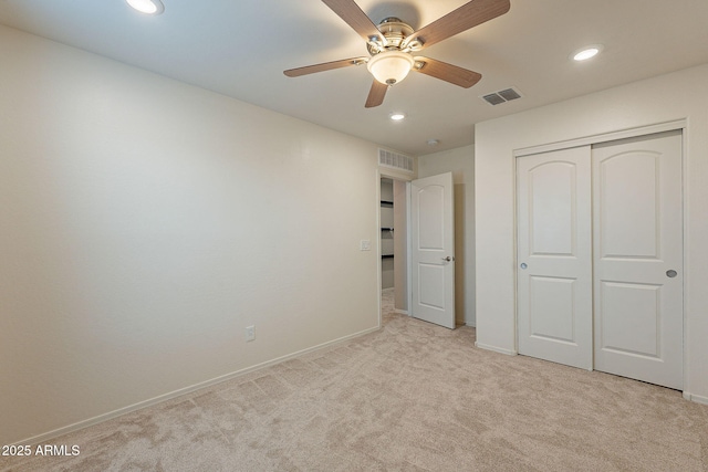 unfurnished bedroom featuring baseboards, visible vents, a closet, and light carpet