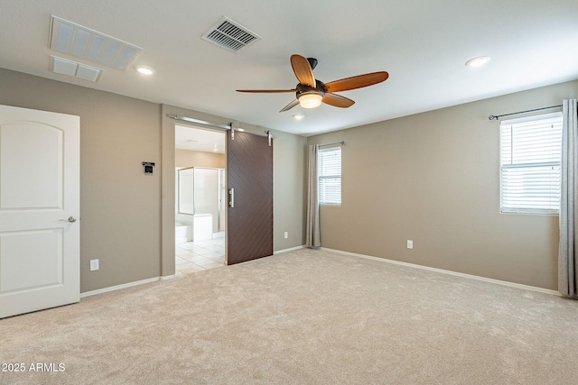 unfurnished room with visible vents, light carpet, recessed lighting, a barn door, and ceiling fan