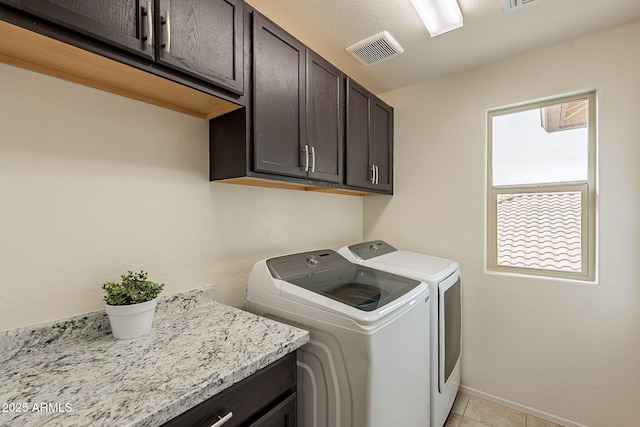 laundry room featuring visible vents, cabinet space, baseboards, and washing machine and dryer