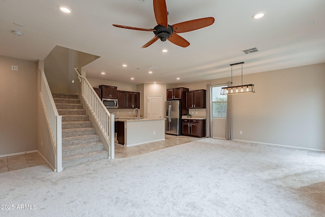 kitchen with visible vents, a ceiling fan, stainless steel appliances, light colored carpet, and dark brown cabinets