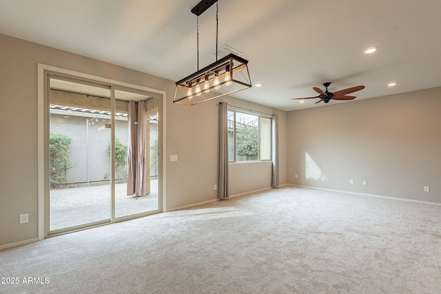 carpeted empty room featuring recessed lighting, ceiling fan with notable chandelier, and baseboards