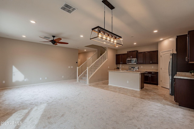 kitchen featuring visible vents, light colored carpet, appliances with stainless steel finishes, and open floor plan