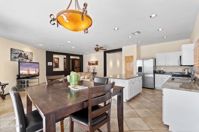 dining room featuring ceiling fan, light tile patterned flooring, and sink