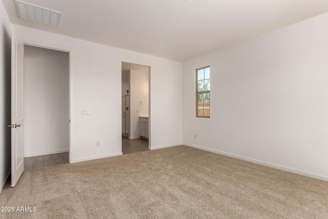 unfurnished bedroom with visible vents, baseboards, ensuite bathroom, and carpet floors