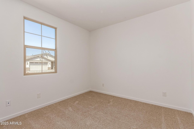 carpeted spare room featuring baseboards