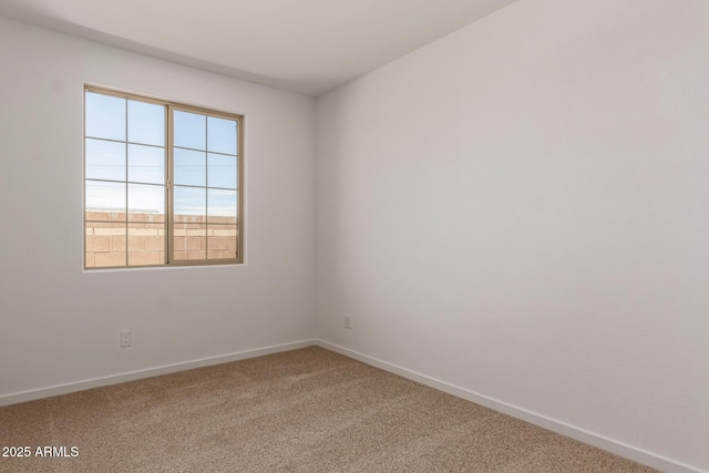 carpeted spare room featuring baseboards