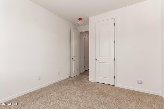 unfurnished bedroom featuring light carpet, baseboards, and visible vents