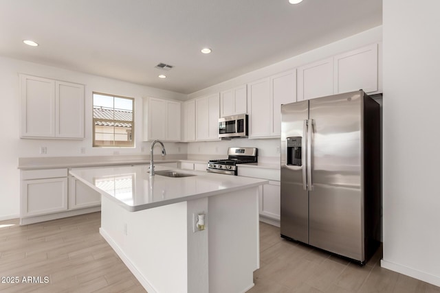 kitchen with a sink, white cabinetry, visible vents, and stainless steel appliances