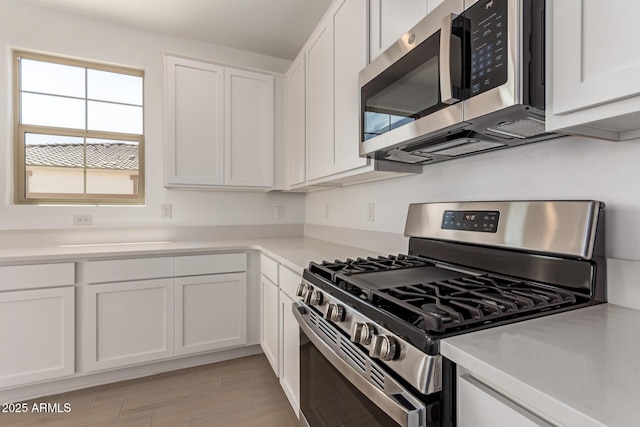 kitchen featuring appliances with stainless steel finishes, light countertops, and white cabinetry