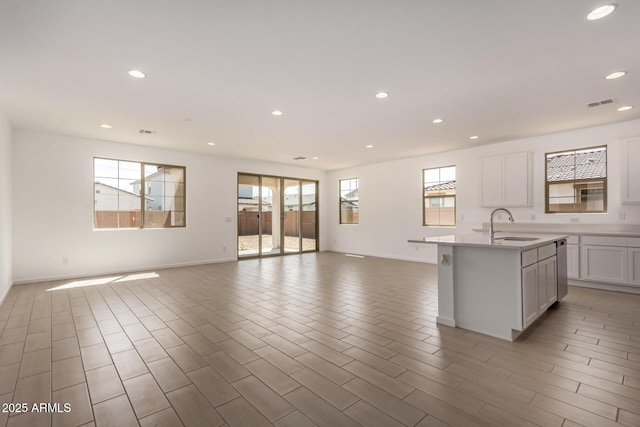 kitchen with recessed lighting, open floor plan, visible vents, and a sink