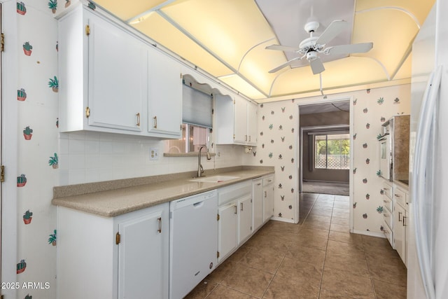 kitchen with white cabinetry, light tile patterned flooring, dishwasher, and sink