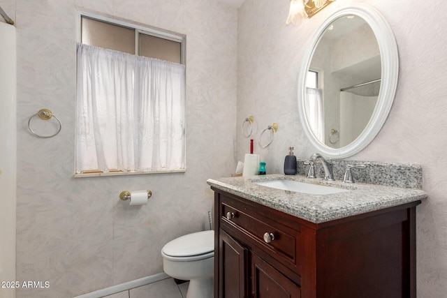 bathroom with tile patterned flooring, vanity, a wealth of natural light, and toilet