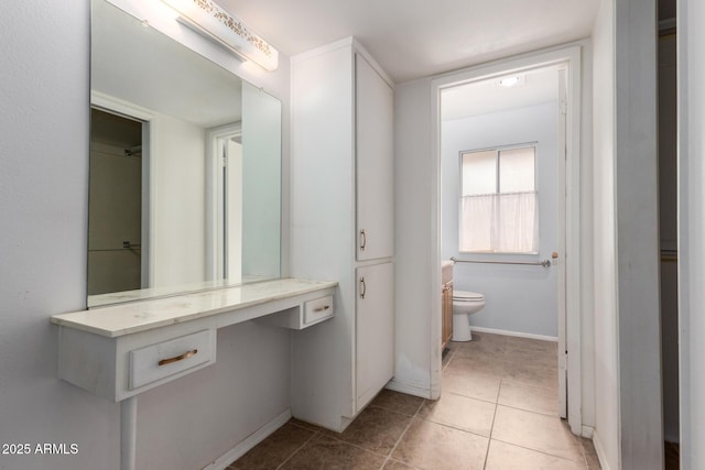 bathroom featuring vanity, tile patterned floors, and toilet