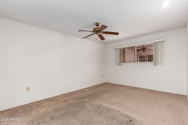 empty room featuring ceiling fan, carpet floors, and a textured ceiling