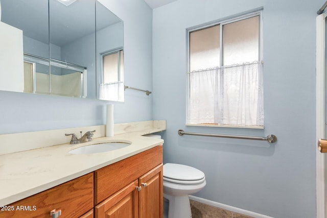 bathroom with vanity, a shower with shower door, and toilet