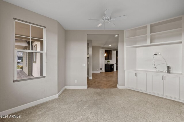 carpeted spare room featuring ceiling fan